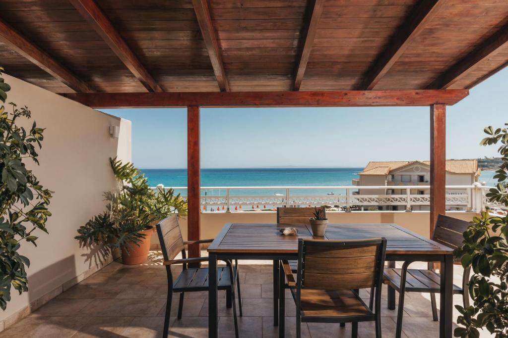 a table and chairs on a patio with the beach at Level 3 Sea View Studio in Planos