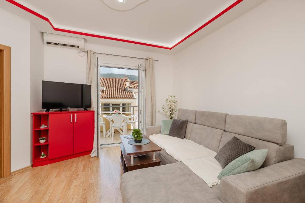 a living room with a couch and a red cabinet at Apartman Stella Đenovići in Đenovići