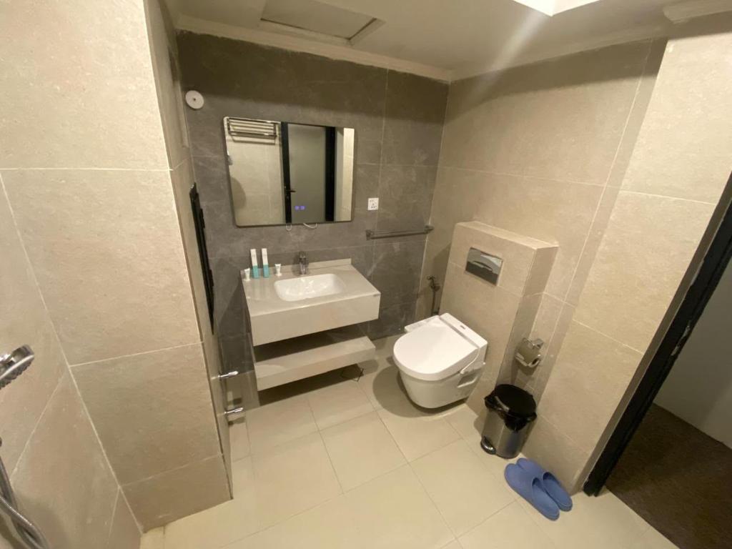 a bathroom with a white toilet and a sink at فندق قصر السدير in Baghdād