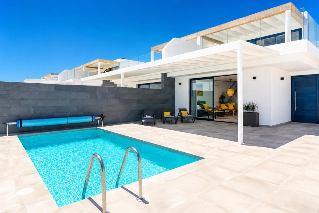 a swimming pool in front of a house at Villa Maria 7 in Puerto Calero