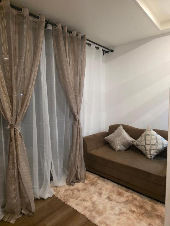 a living room with a couch and curtains at Megarich Studio in Megatower VII in Baguio