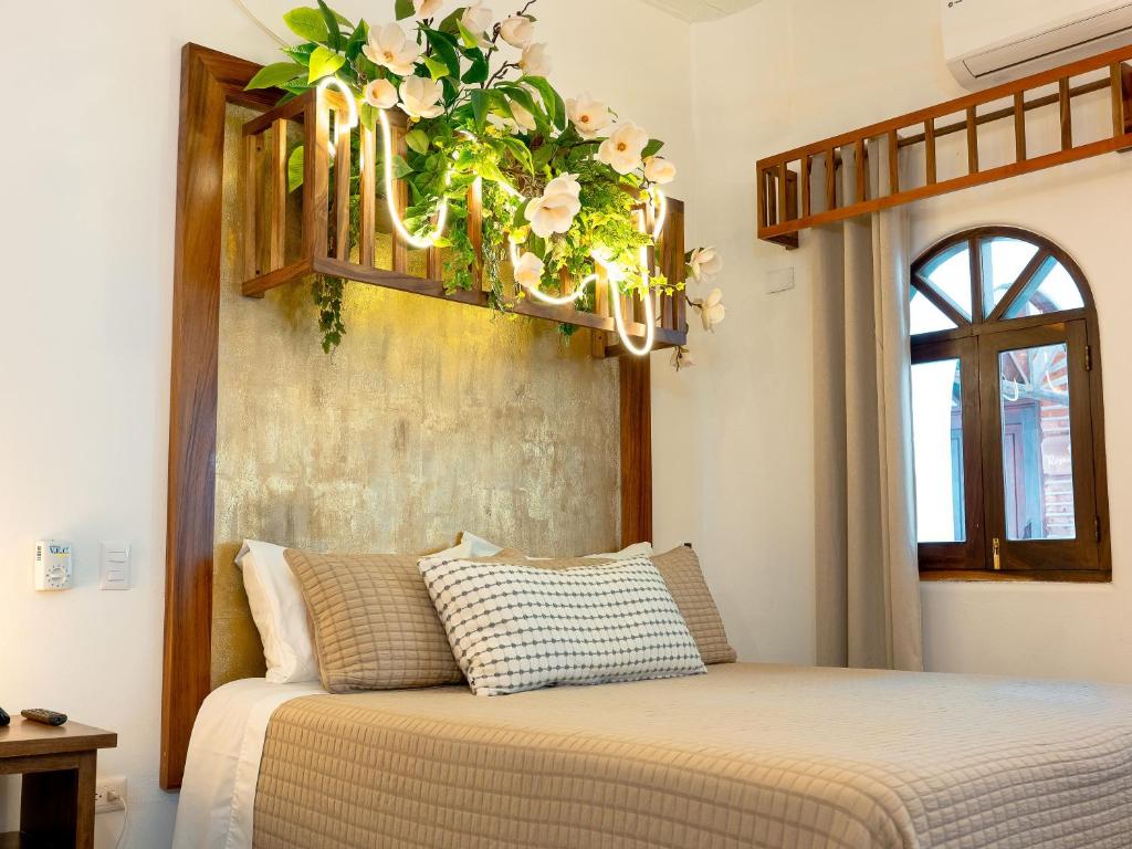 ein Schlafzimmer mit einem Bett und einem Kronleuchter mit Blumen in der Unterkunft QUINTA BERNAL in Lo de Marcos