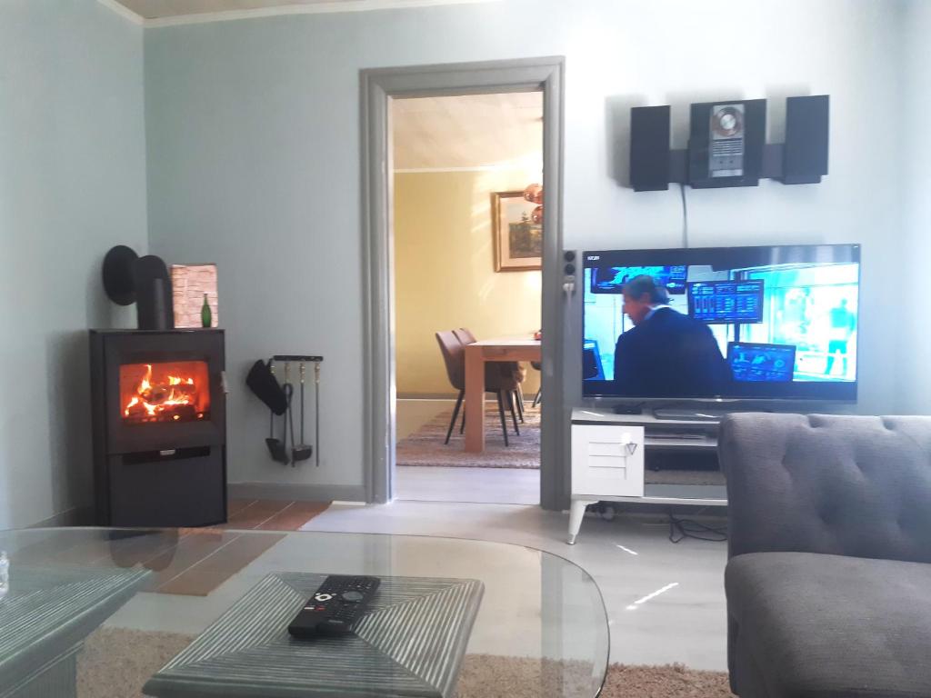a living room with a tv and a fireplace at Charming Villa close to the sea in Errindlev