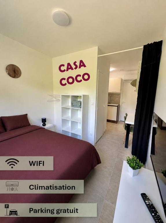 a bedroom with a bed and a csa coo sign at Studio CASA COCO-2pers Béligneux in Béligneux