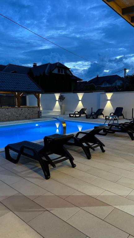 a row of tables sitting on a patio at night at Villa SARA Bugojno in Bugojno