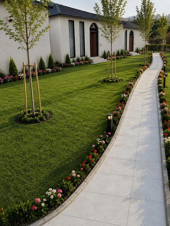 a walkway in a yard with flowers and a house at Al Badr Villas Resort in Sawdāʼ