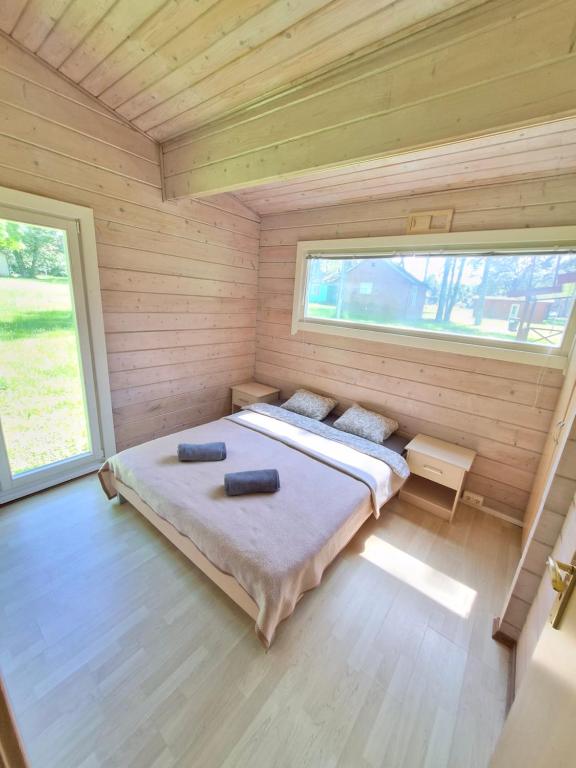 a bedroom with a bed in a wooden house at Giruliu kopa in Melnragė