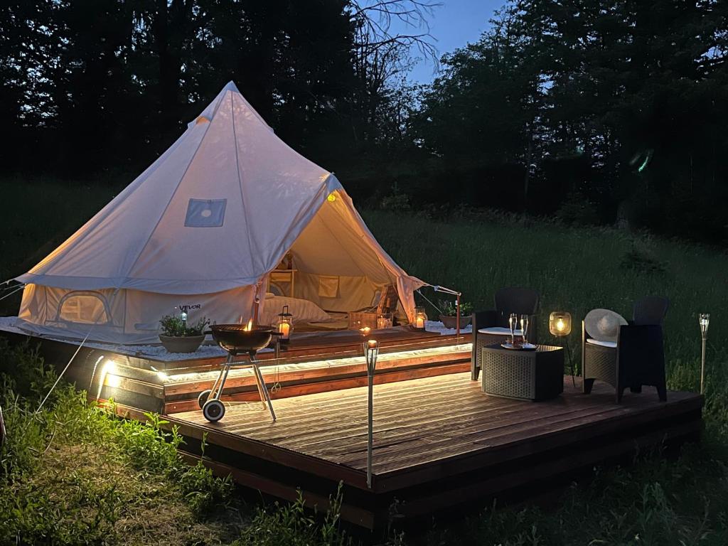 a tent sitting on a wooden deck in a field at Vrhnika hill in Vrhnika