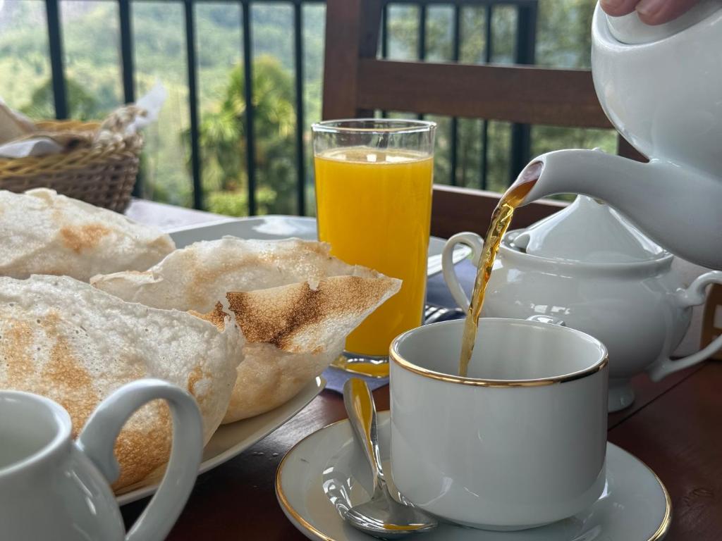 a table with a cup of coffee and some toast at Senu Ceylon Ella in Ella