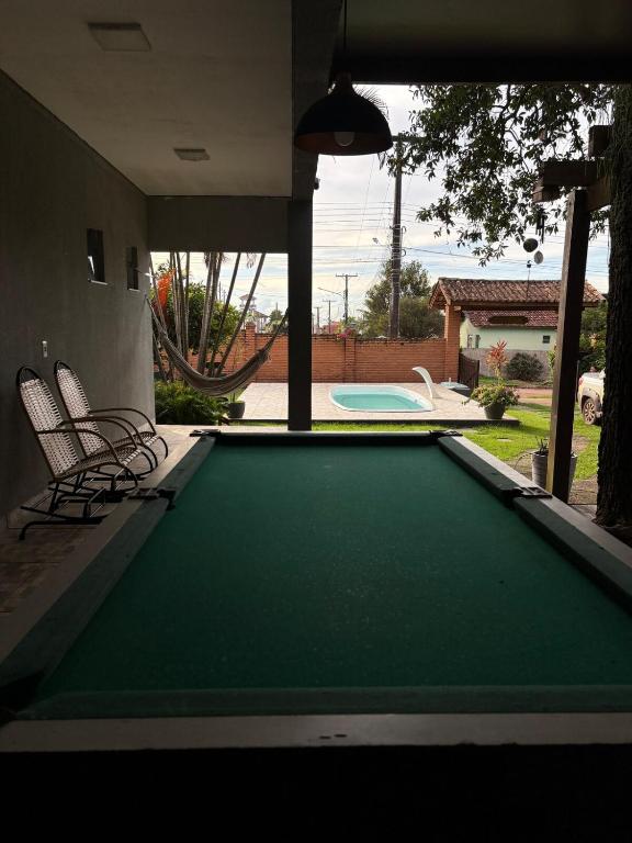 a pool table in a house with two chairs at Recanto R2V in Chapada dos Guimarães
