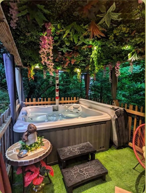 a jacuzzi tub in a room with plants at La Cabane Enchanteresse in Illoud