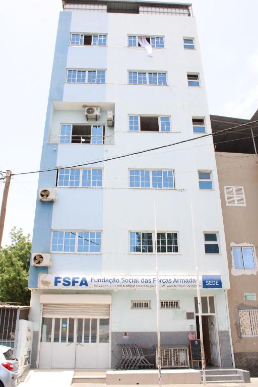 a tall white building with a fiesta sign on it at Residencial FSFA in Praia