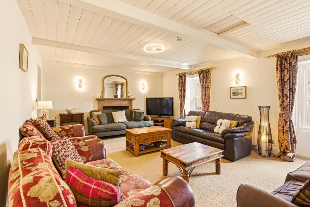 a living room with couches and a tv at Ghyllstead - North East Escapes in Glanton