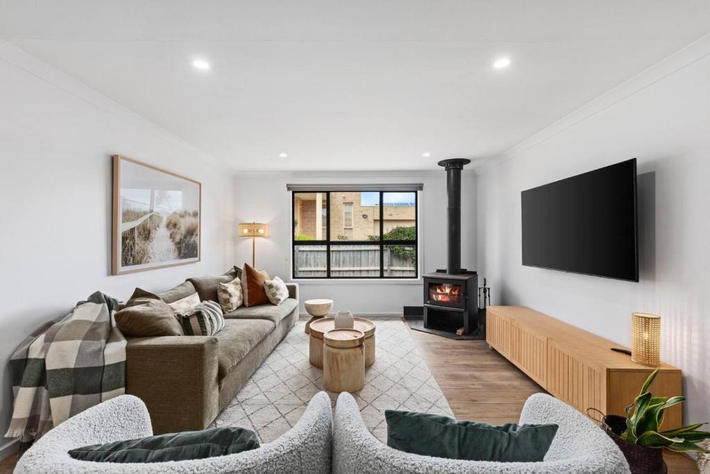 a living room with a couch and a fireplace at Chic coastal living in Anglesea