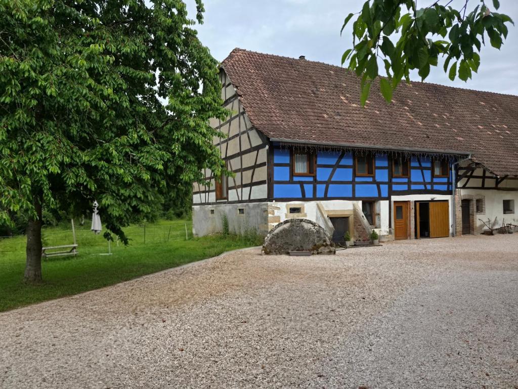 a blue and white house with a gravel driveway at Marie-Thérèse in Manspach