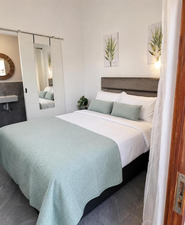a bedroom with a large bed and a mirror at 60 On Kosmos in Bellville South