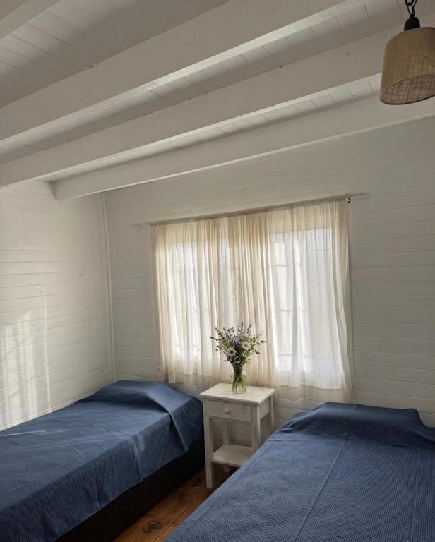 two beds in a room with a window at Casa Sauce Delta in Tigre
