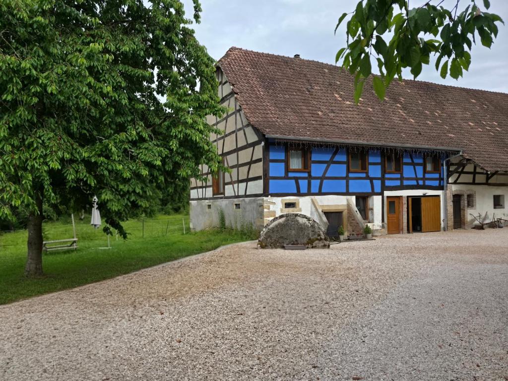 a blue and white house with a gravel driveway at Achille in Manspach