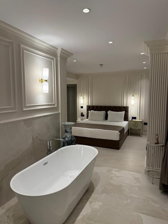 a bathroom with a bath tub and a bed at DriArt Center in Tirana