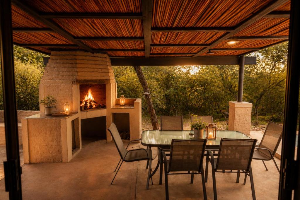 a patio with a table and a fireplace at Wonderviews Hedgehog in Marloth Park