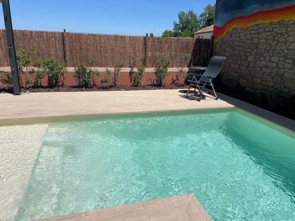 a swimming pool with a chair next to a fence at Casa Zacarias - Bonitas vistas en La Rioja in Herramélluri