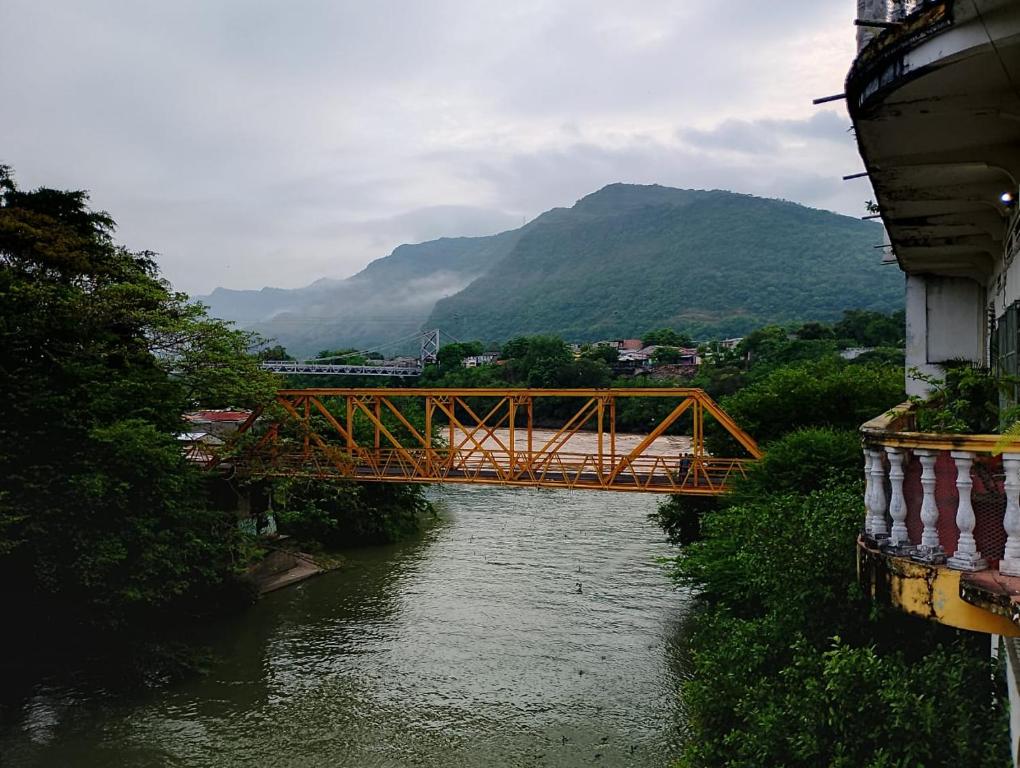 a bridge over a river next to a mountain at Remanso del Río in Honda