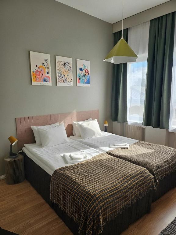 a bedroom with a large bed with white sheets at Hotel Suonenjoki in Suonenjoki