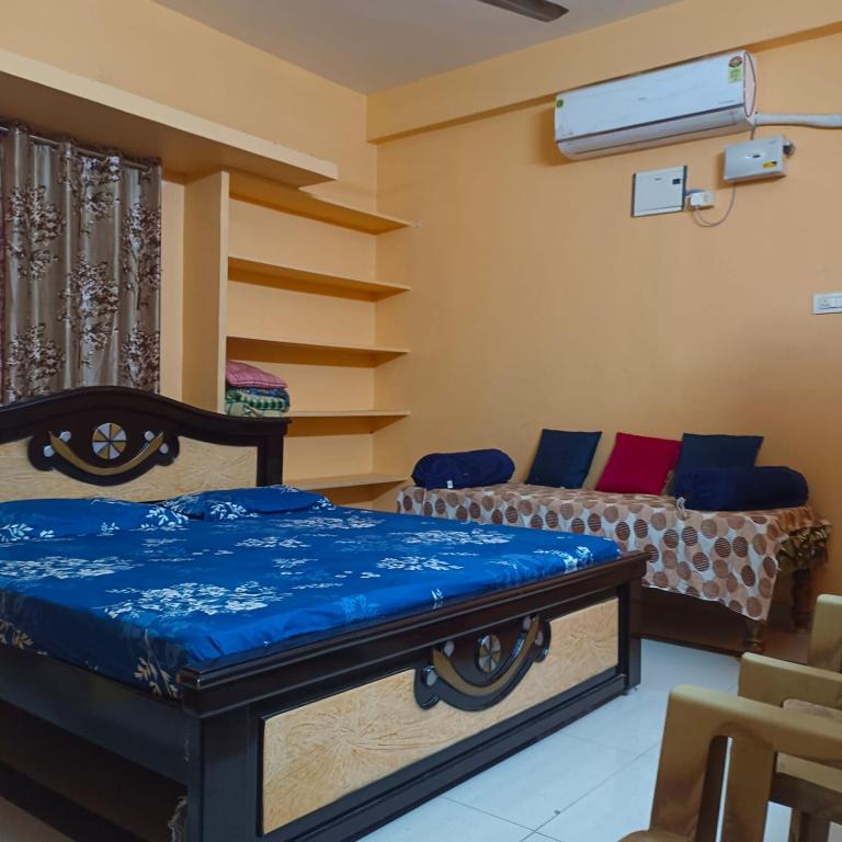 a room with two beds and a couch at Jyothi swaroop bhakta nivas in Tirupati