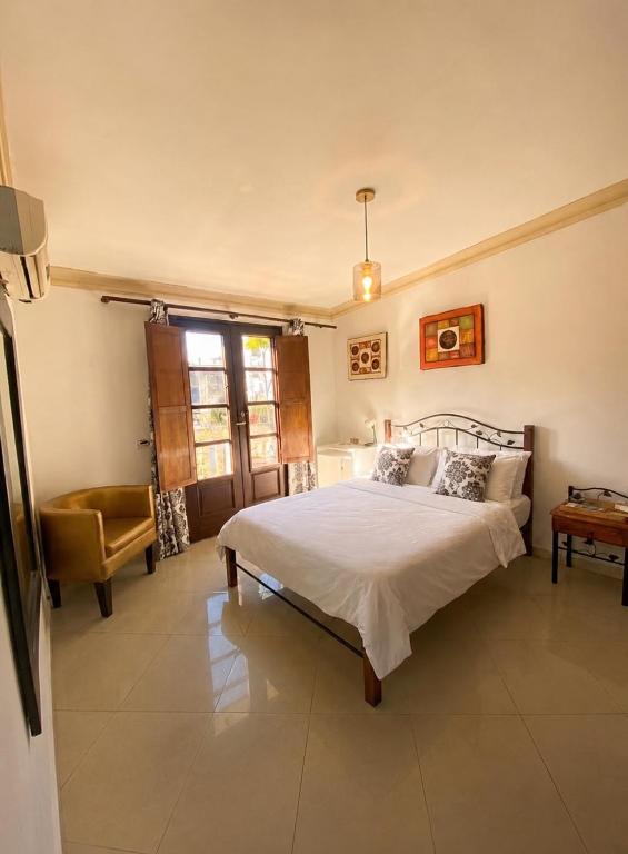a bedroom with a bed and a chair at La casita de Adri habitación privada en alojamiento compartido en zona colonial in Santo Domingo