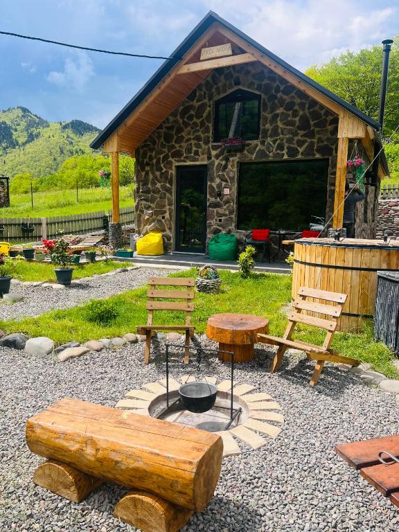 a group of benches and tables in front of a building at Woodlandia Borjomi with Hot Tub and Private Garden in Borjomi