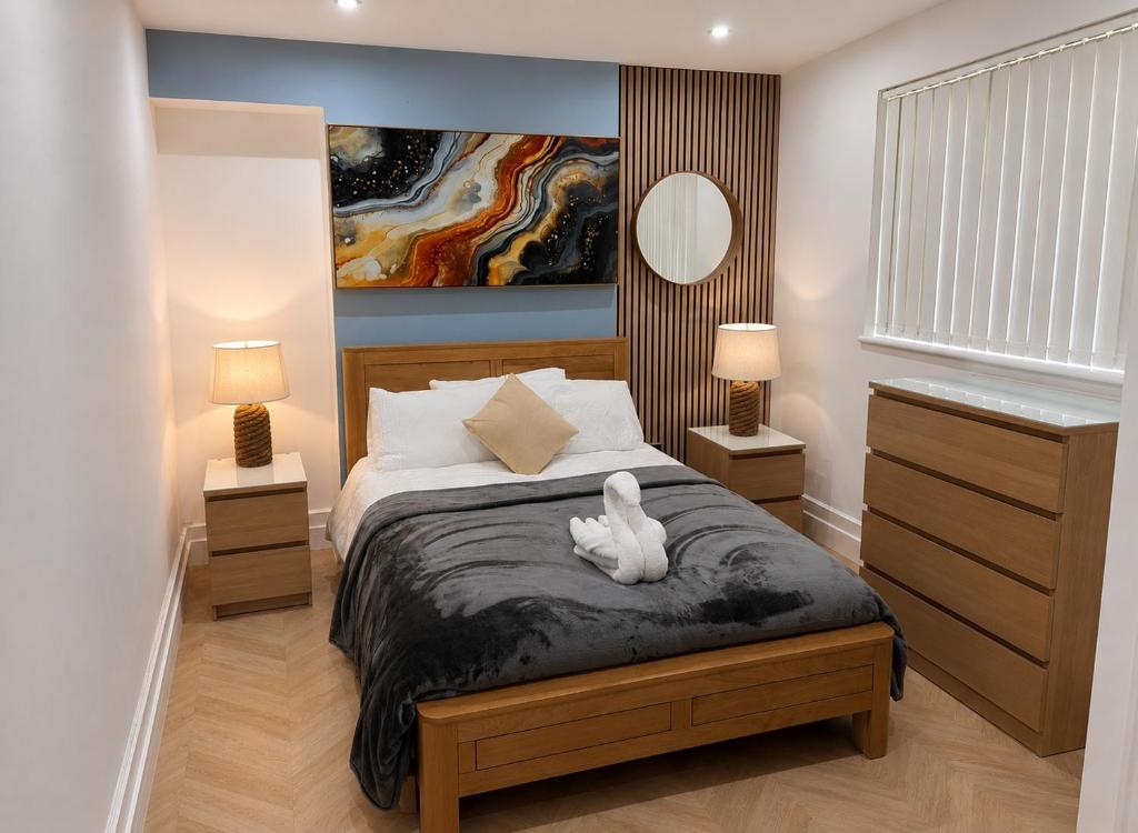 a bedroom with a bed with a white animal on it at Hendham Rooms - Near Etihad Stadium, CoOp Live Arena, National Cycling Centre & 24 Hour Asda in Manchester