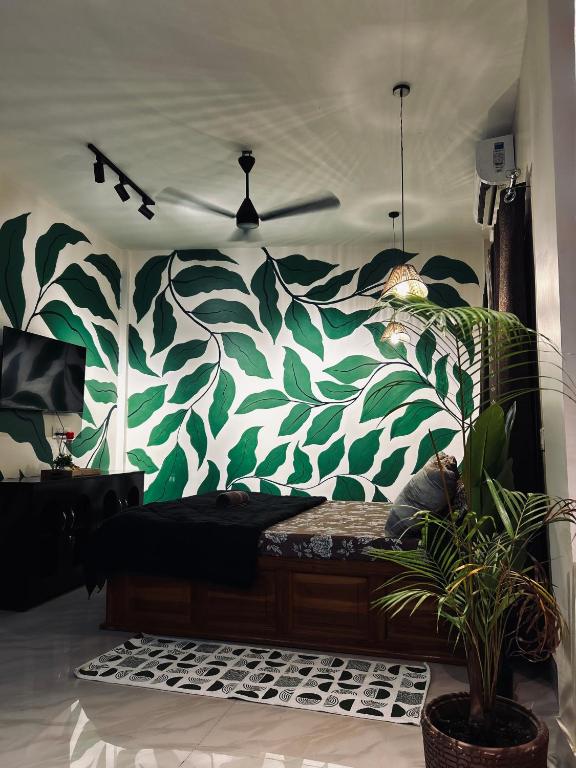 a room with a wall with a green and white mural at Oak & olive stays in Tezpur