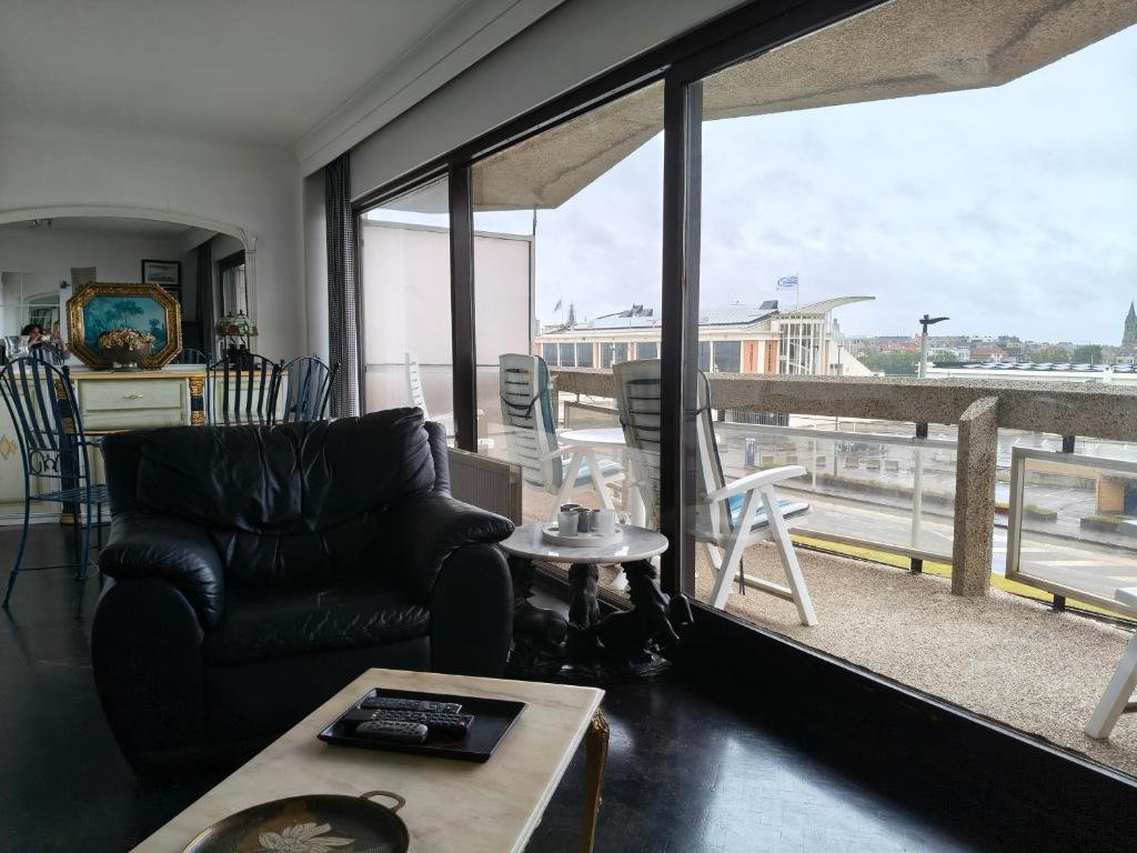 a living room with a couch and a large window at Residentie Aldis met 1 slaapkamer in Ostend