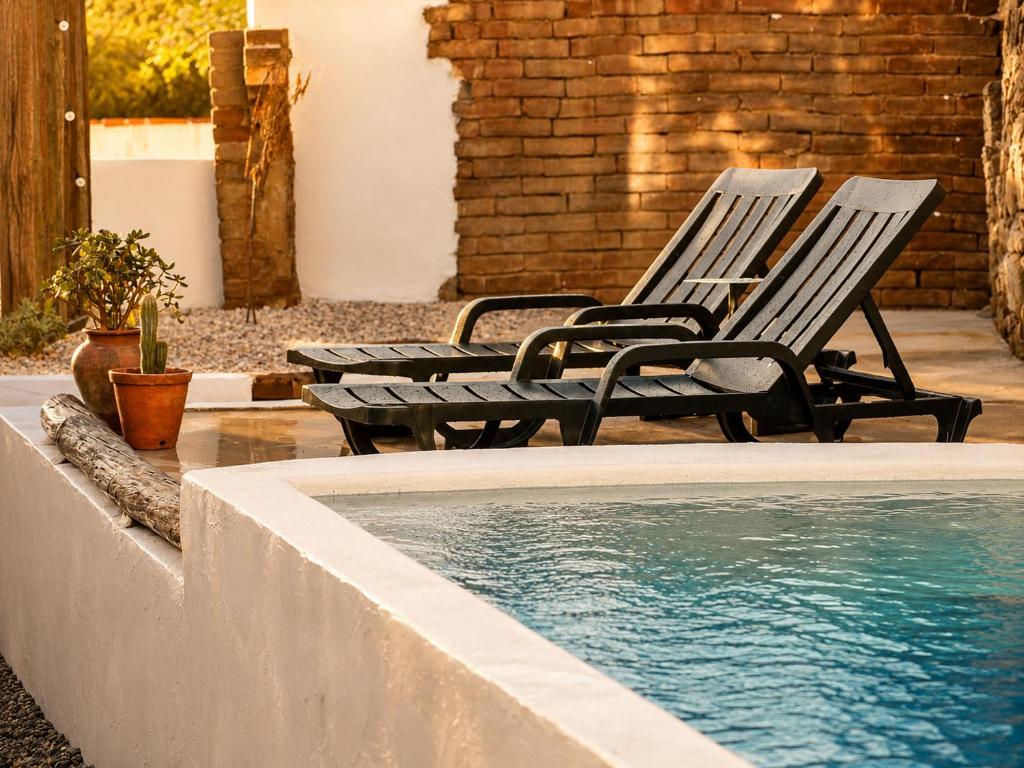 two chairs sitting next to a swimming pool at Casa do tio Frade in Aldeia do Mato