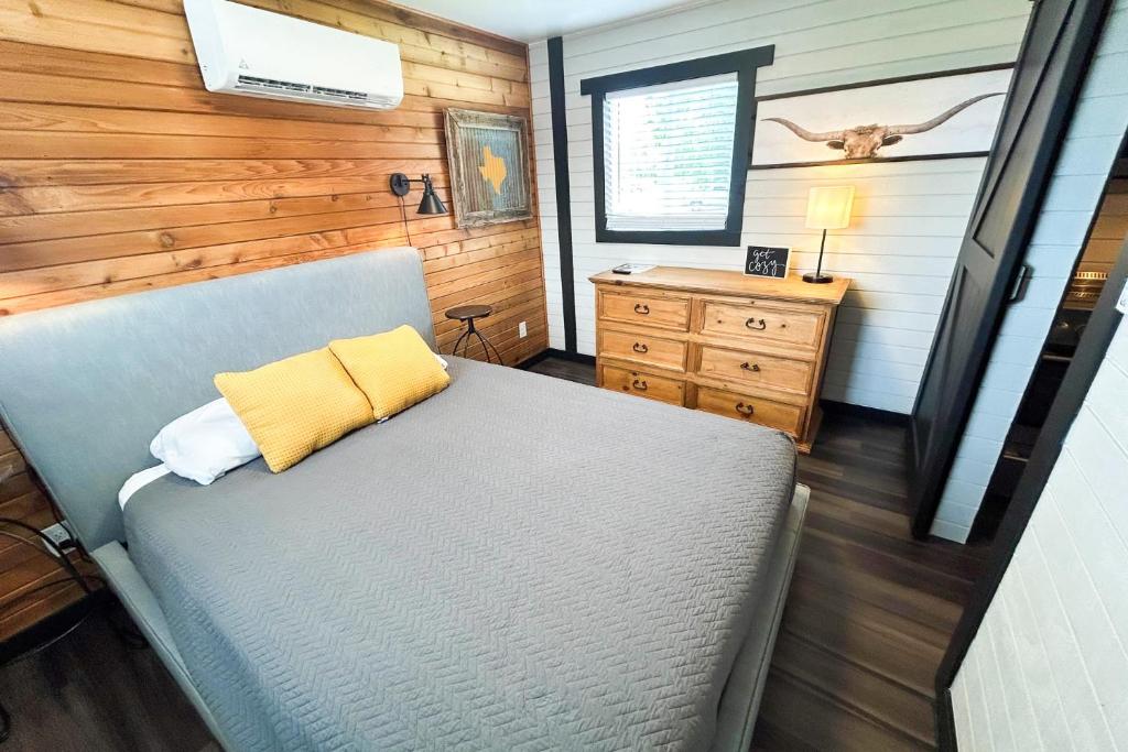 a bedroom with a bed with a yellow pillow on it at Red Barn North - 40 in Mead