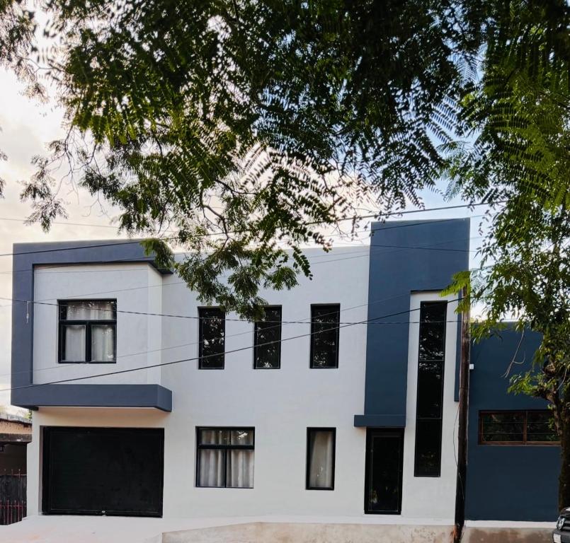 a white and blue building with black windows at SomosRio II Apart in La Cruz