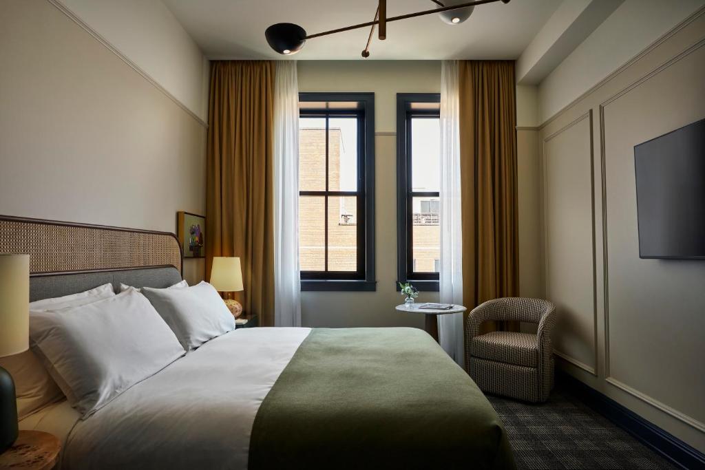a hotel room with a bed and a tv at Cincinnati's Fidelity Hotel in Cincinnati