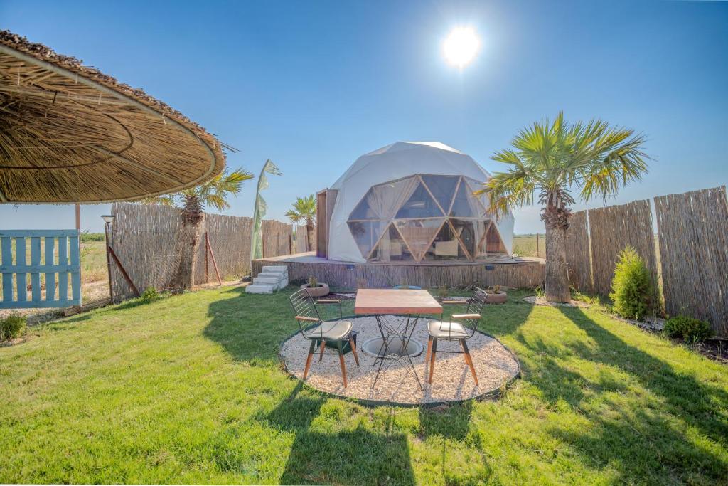 a tent in a yard with a table and chairs at Belek Glamping House in Çakıllık