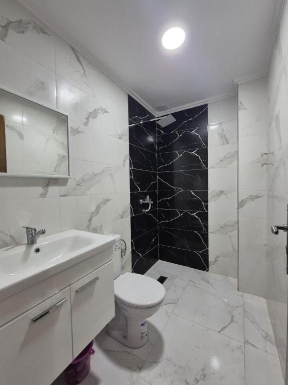 a white bathroom with a toilet and a sink at Calm and facinating vacation in Saïdia
