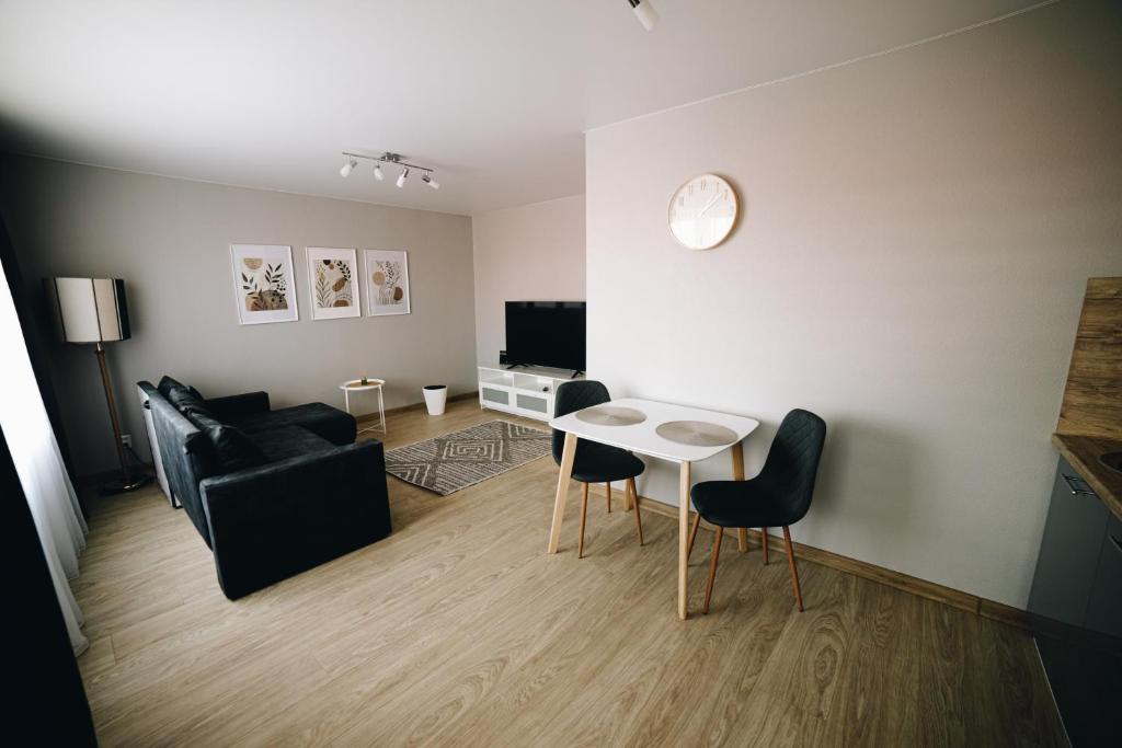 a living room with a couch and a table at LK Darzu Apartment in Rēzekne