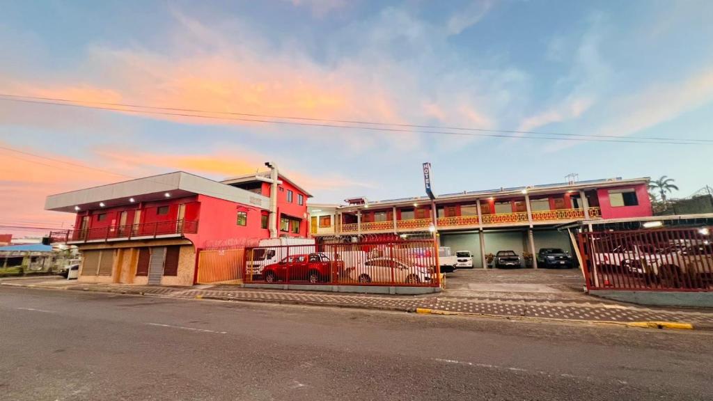 a red building on the side of a street at Hotel Costa del Sol in Puerto Limón