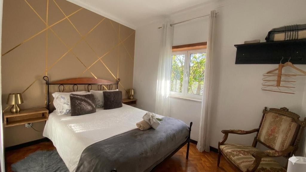 a bedroom with a bed and a chair and a window at Alojamento D. Duarte in São Paio