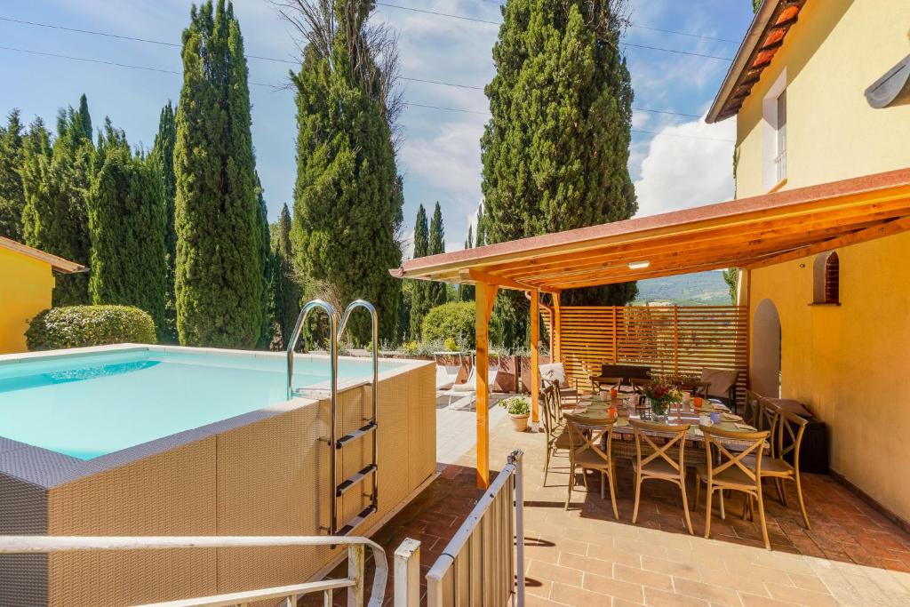 a patio with a pool and a table and chairs at La Casa delle Farfalle in Chiusi