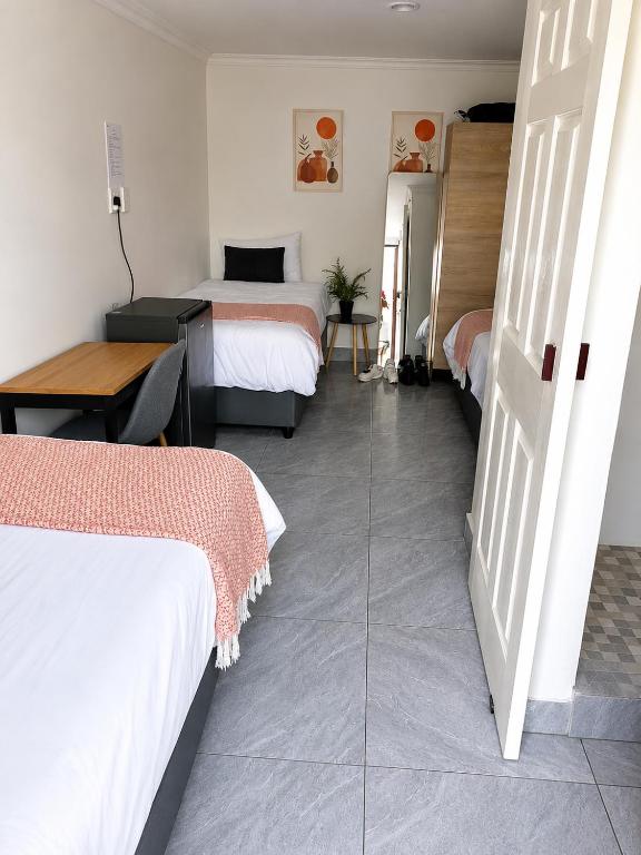 a room with two beds and a table and a desk at 60 On Kosmos in Bellville South
