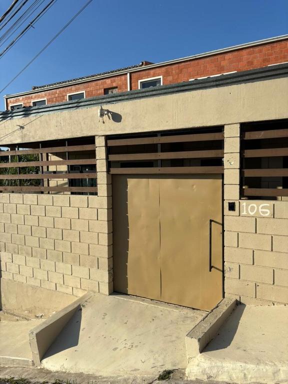 a brick building with a garage door on it at Vila Chacrinha apartamento 2 in Campo Limpo