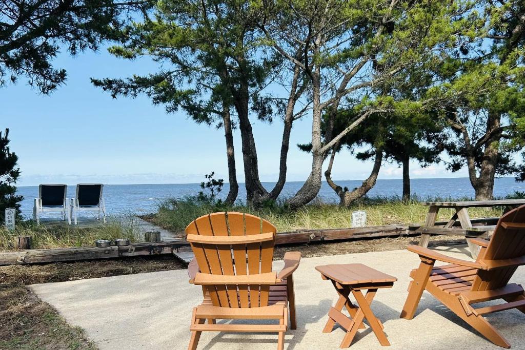 two chairs and a table and a picnic table and the ocean at 229 Bay Ave. in Milford
