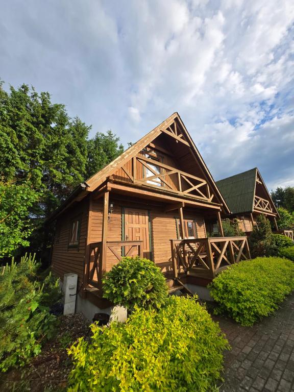 a large wooden house with a gambrel at Hacjenda in Redło
