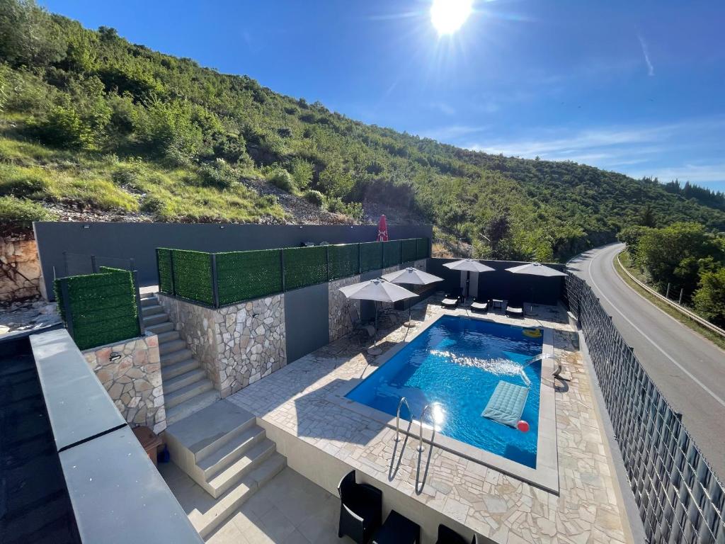 a swimming pool on top of a building with a mountain at Villa Pietra in Stolac