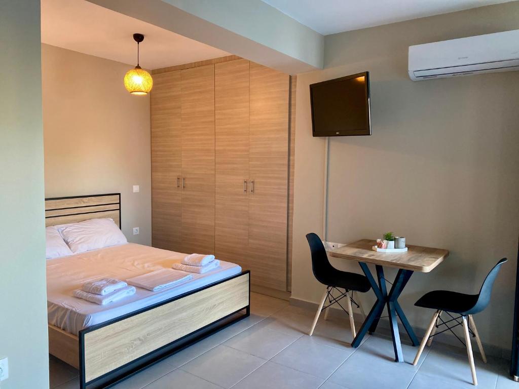 a bedroom with a bed and a table with chairs at Regium Studio in Nikiana