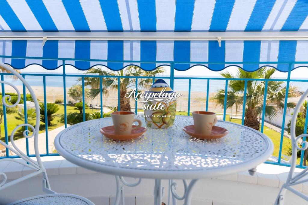 a table with two coffee cups on a balcony at Arcipelago Suite in Belvedere Marittimo